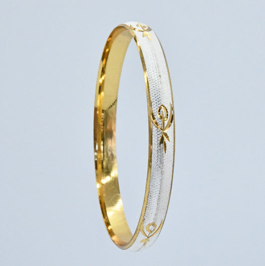 Gold and silver coloured alloy bracelet with intricate designs on a light gray background