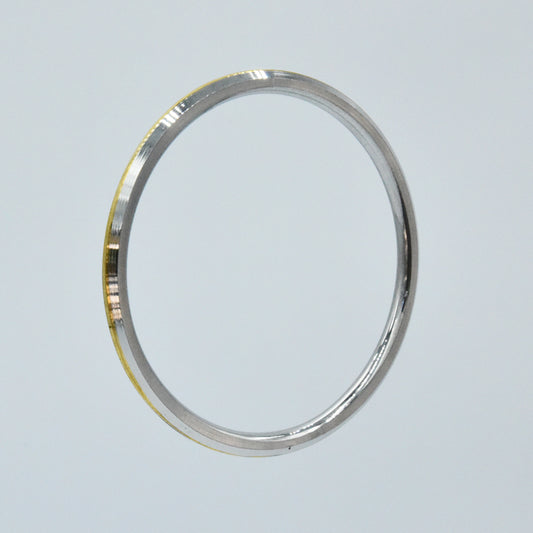 Steel and brass kara on a light gray background