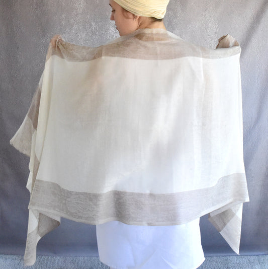 Person wearing a light beige shawl over their shoulders against a neutral background