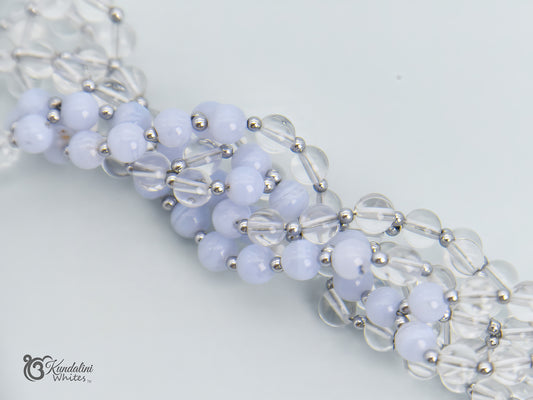 Close-up of a blue lace agate and clear quartz tantric mala on a white background