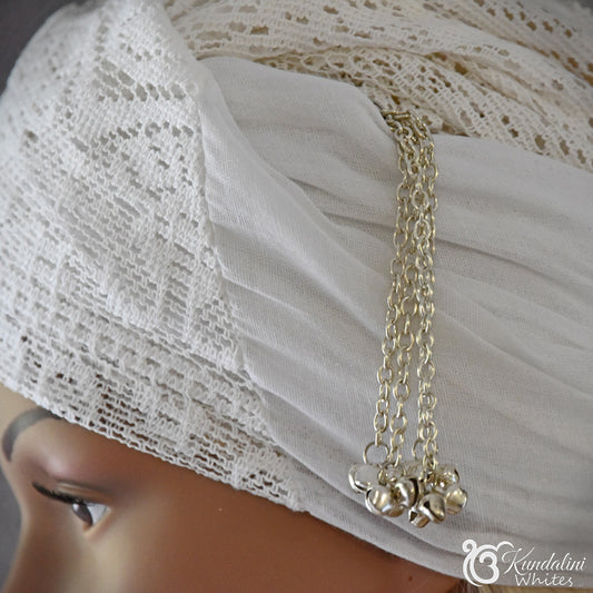 Ornament with small pendants on a mannequin head wearing a white lace turban.