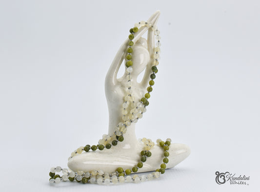 Yoga sculpture with green tantric beads on a white background