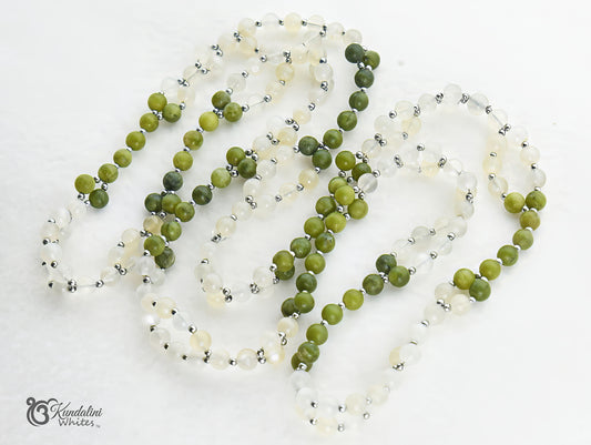 Green and white tantric necklace on a white background