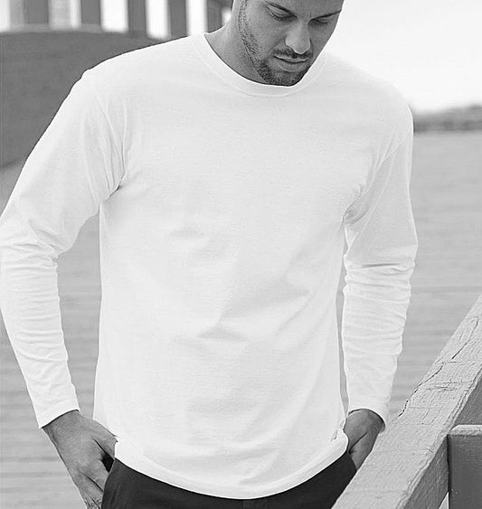 Man wearing a white long-sleeve shirt standing outdoors.