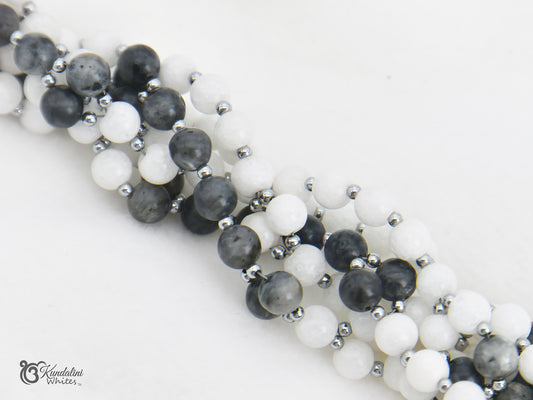 Tantric necklace with black, white, and gray beads on a white background