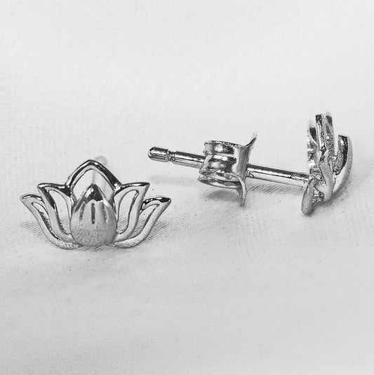 Silver lotus flower earrings on a light gray background