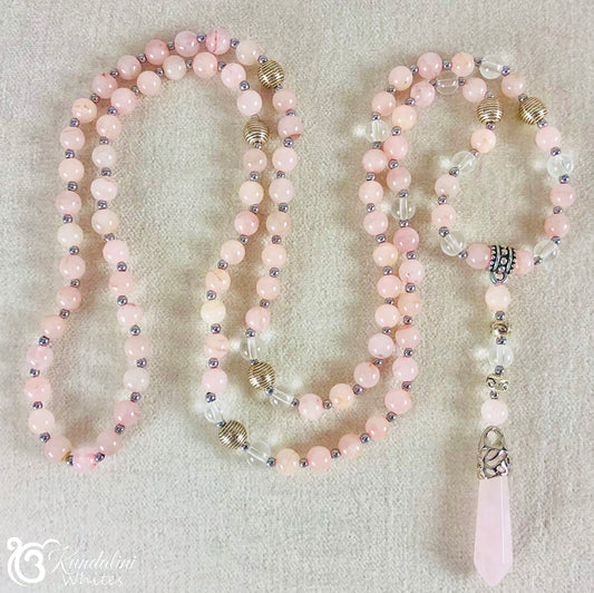 Pink beaded rose quartz mala necklace with silver accents on a light gray background