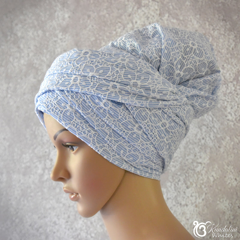 Mannequin head wearing a blue patterned turban against a neutral background