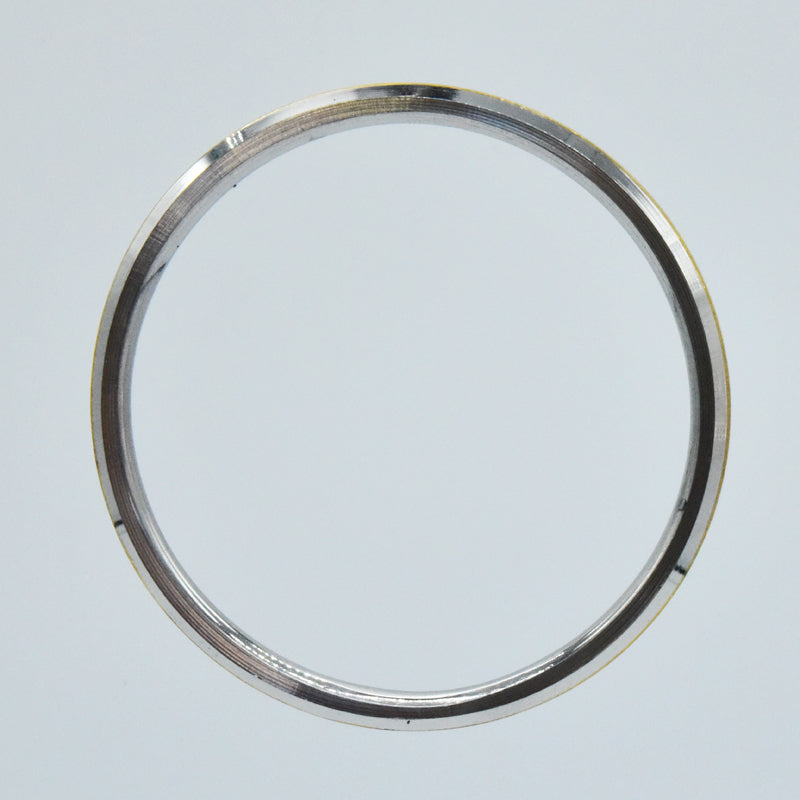 Steel and brass kara on a light gray background