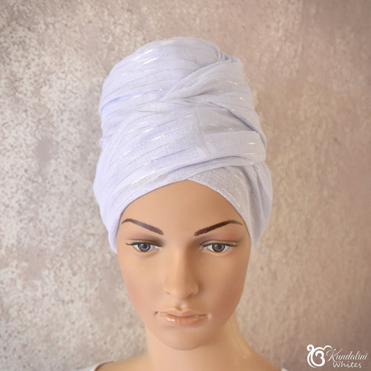 Mannequin head wearing a light lilac turban against a neutral background
