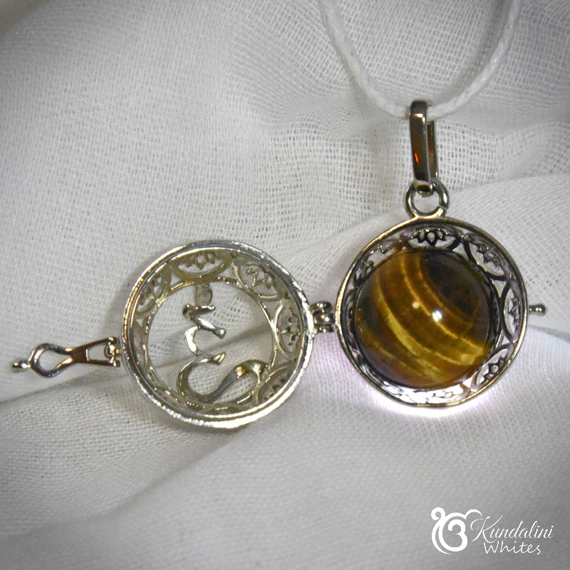 Silver pendant with a tiger's eye stone on a white fabric background