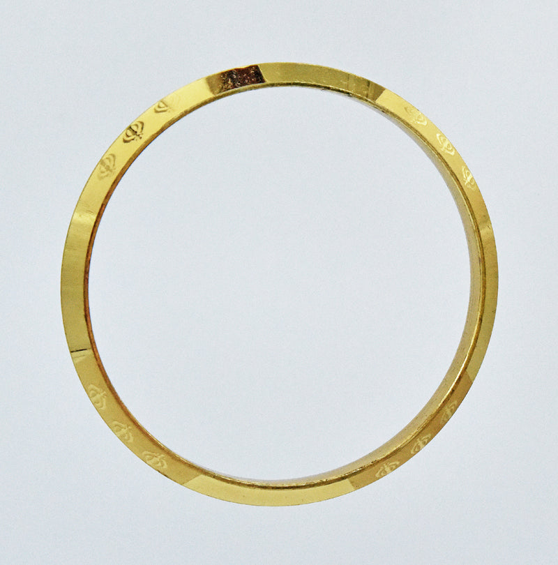 Gold coloured alloy bracelet on a light gray background