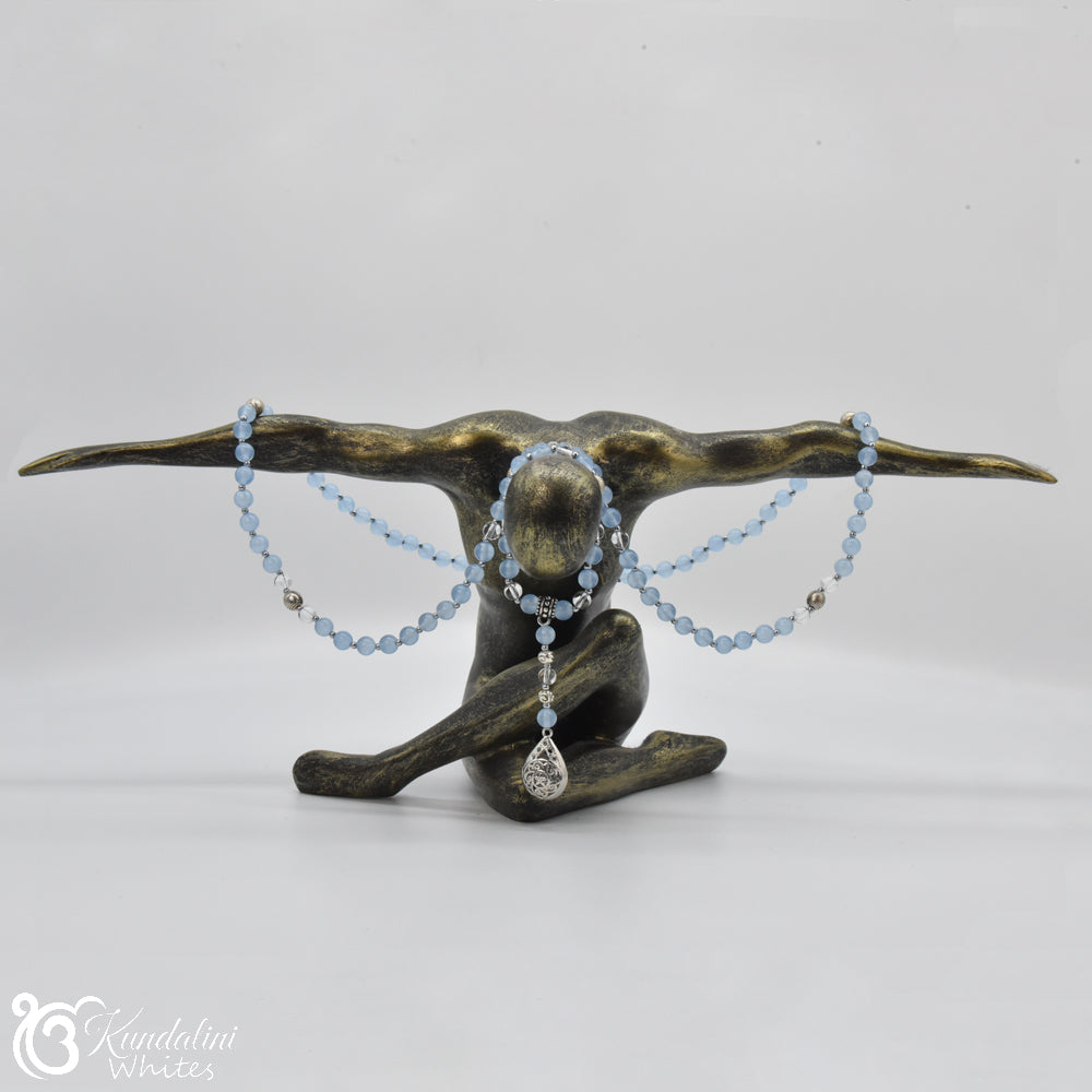Bronze sculpture of a figure holding blue beaded necklaces on a white background