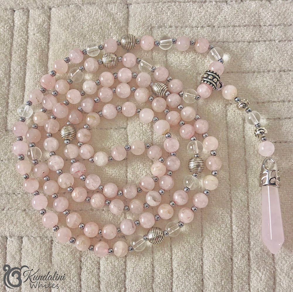 Necklace with pink beads and silver accents on a textured surface