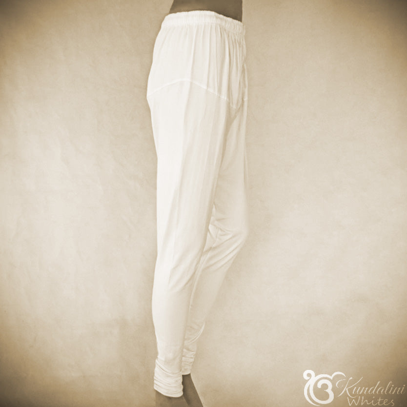 White pants on a mannequin against a beige background with 'Kundalini Whites' branding.