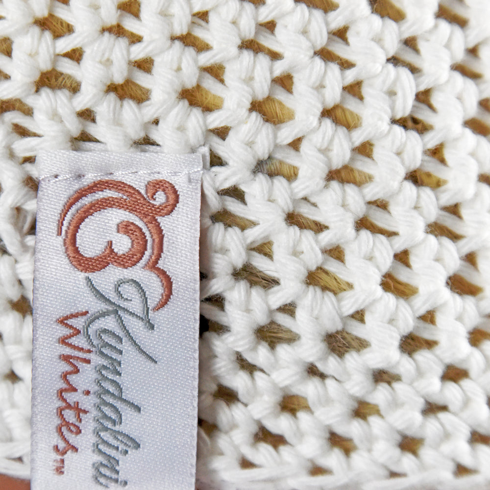 Close-up of a woven fabric with a label reading 'Kundalini Whites'.