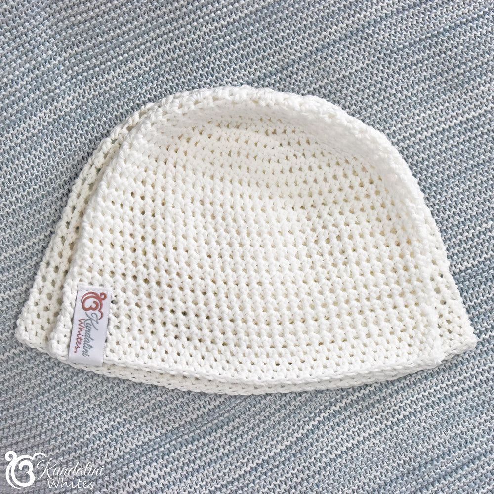Size comparison of two white crocheted yoga hats on a textured gray background