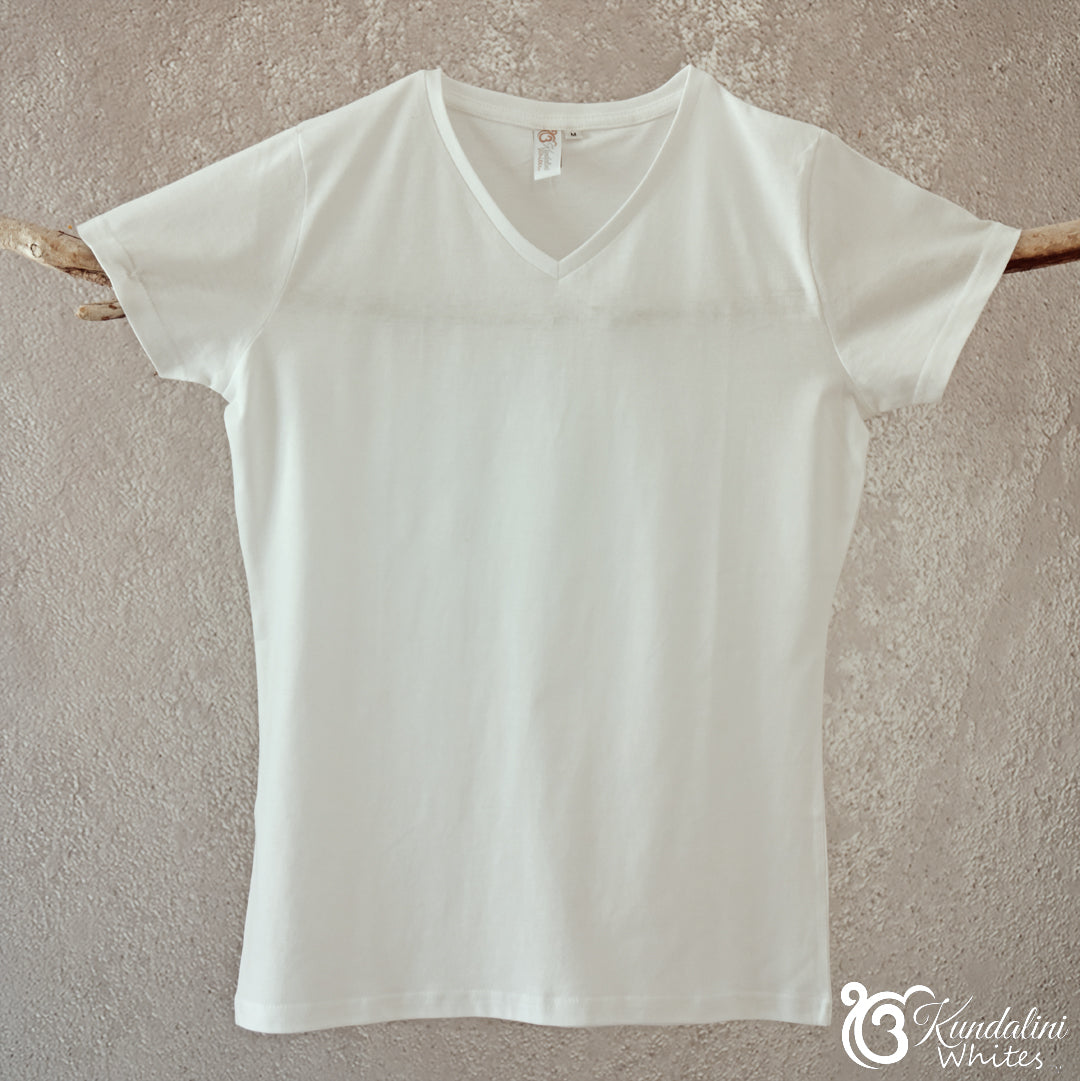 White t-shirt on a wooden hanger against a beige wall
