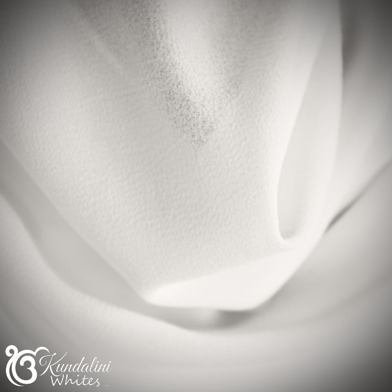 Close-up of white fabric with a subtle texture, featuring the Kondelini Whites logo.