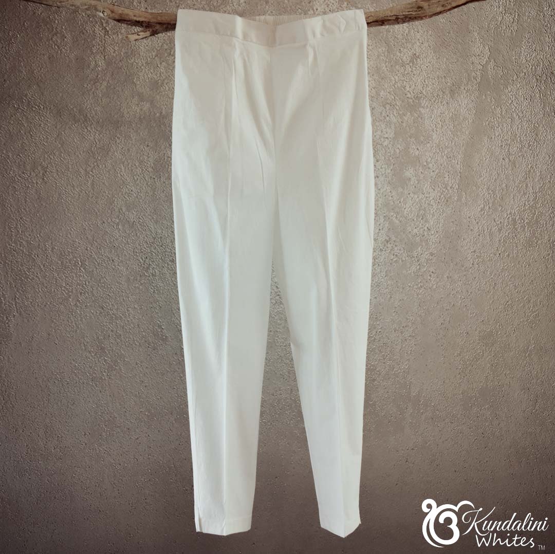 White pants hanging against a textured beige wall with 'Kundalini Whites' branding.