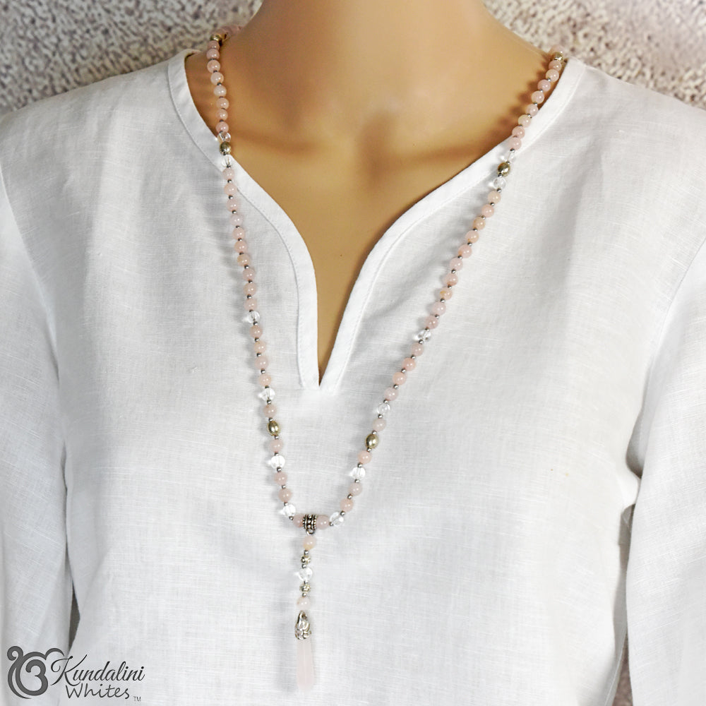 Mannequin wearing a white blouse with a beaded necklace, brand 'Kundalini Whites' visible.