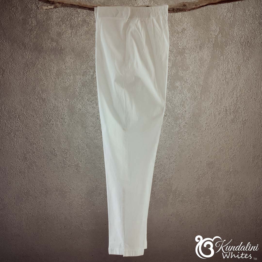 White pants hanging against a textured brown wall with 'Kundalini Whites' branding.