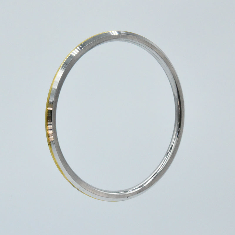 Steel and brass kara on a light gray background