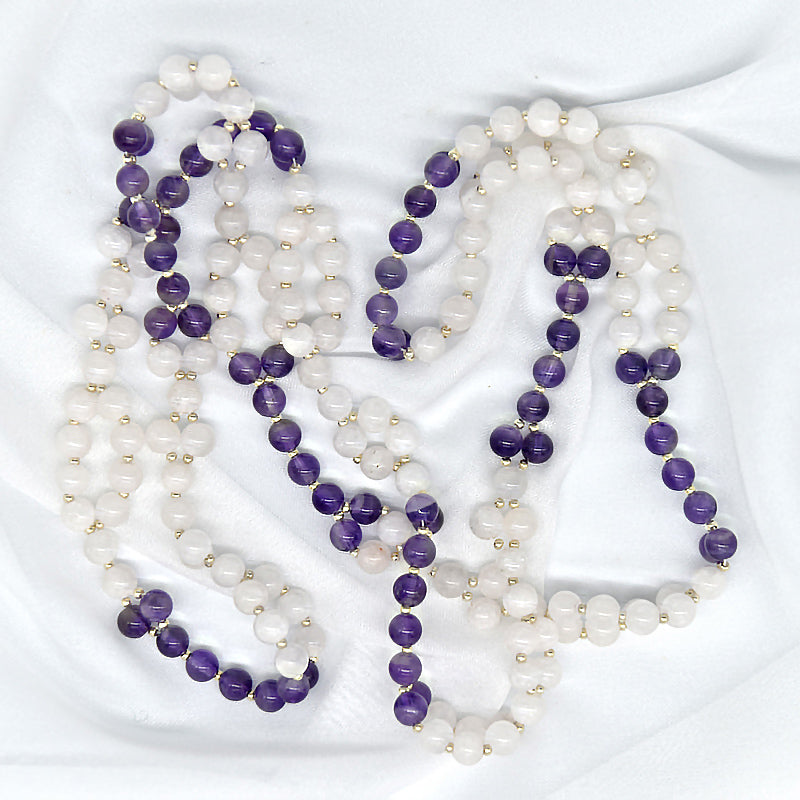 Long beaded necklace with purple and white beads on a white background