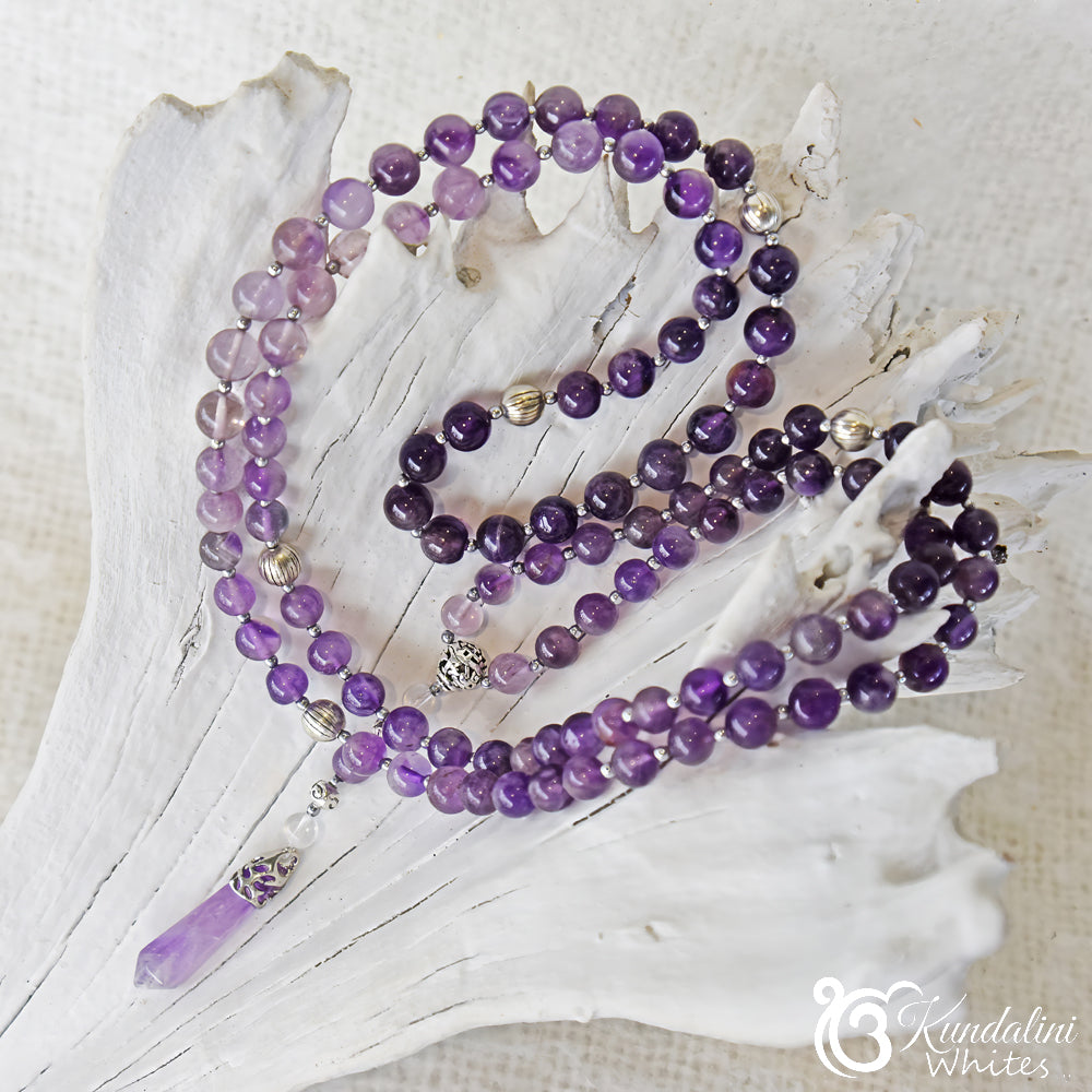 Purple beaded mala necklace on a white shell with 'Kundalini' branding.