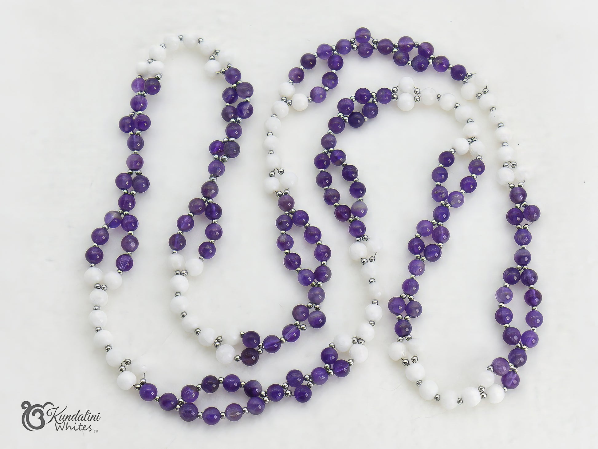 Purple and white beaded tantric necklace with silver accents on a white background