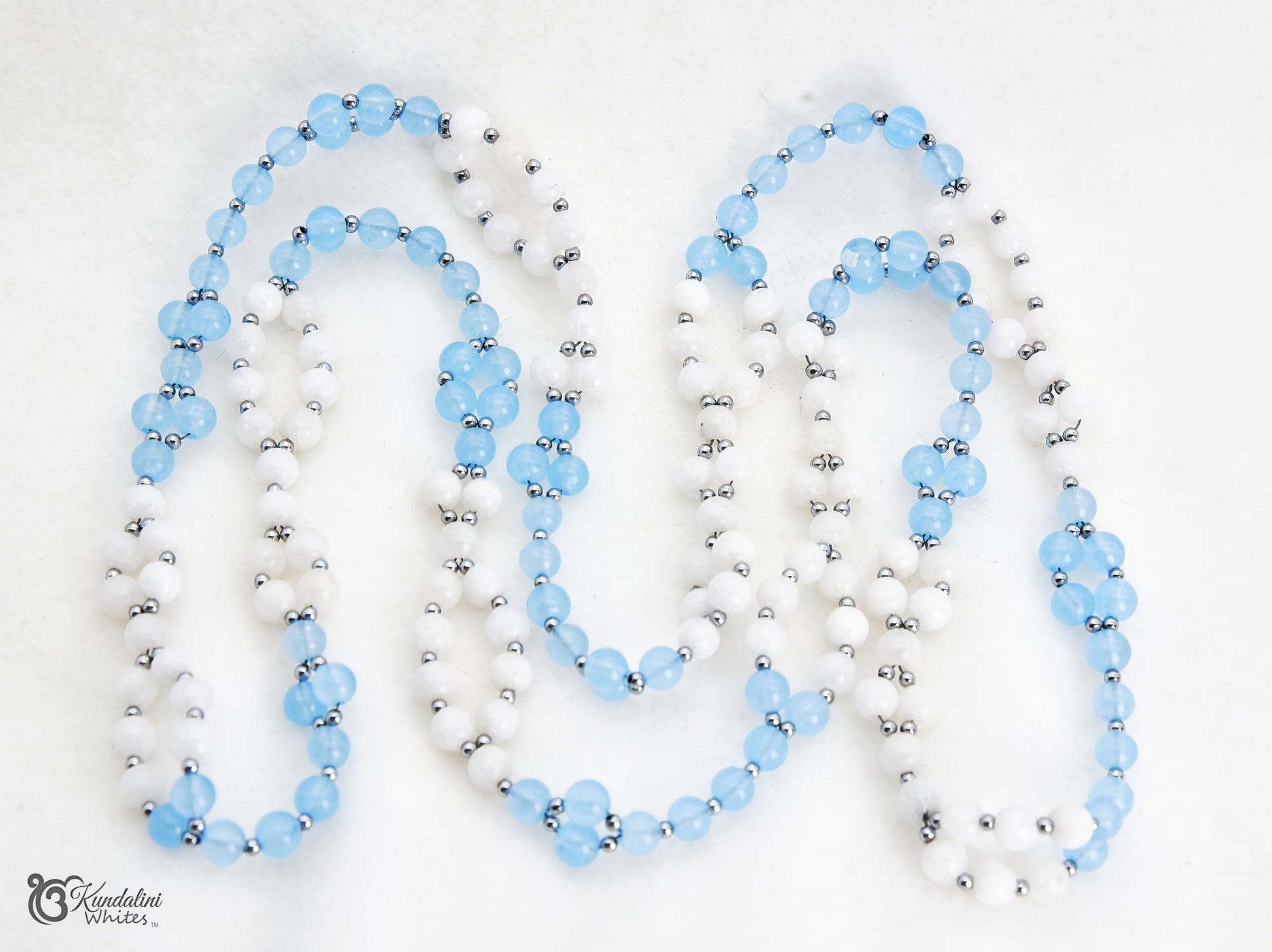 An aquamarine and white agate Tantric Mala arranged in loops on a white background.