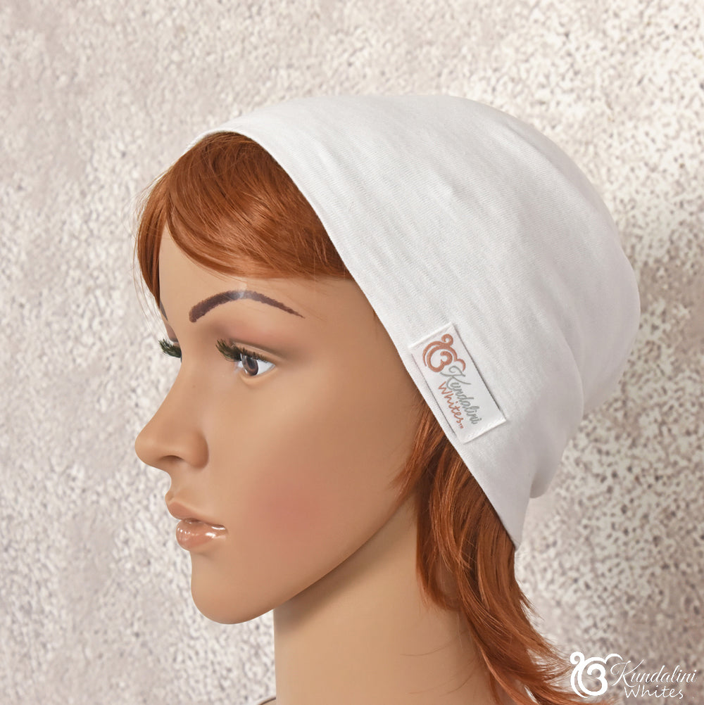 Mannequin head with a white stretch fabric beanie and visible brand logo on a textured beige background