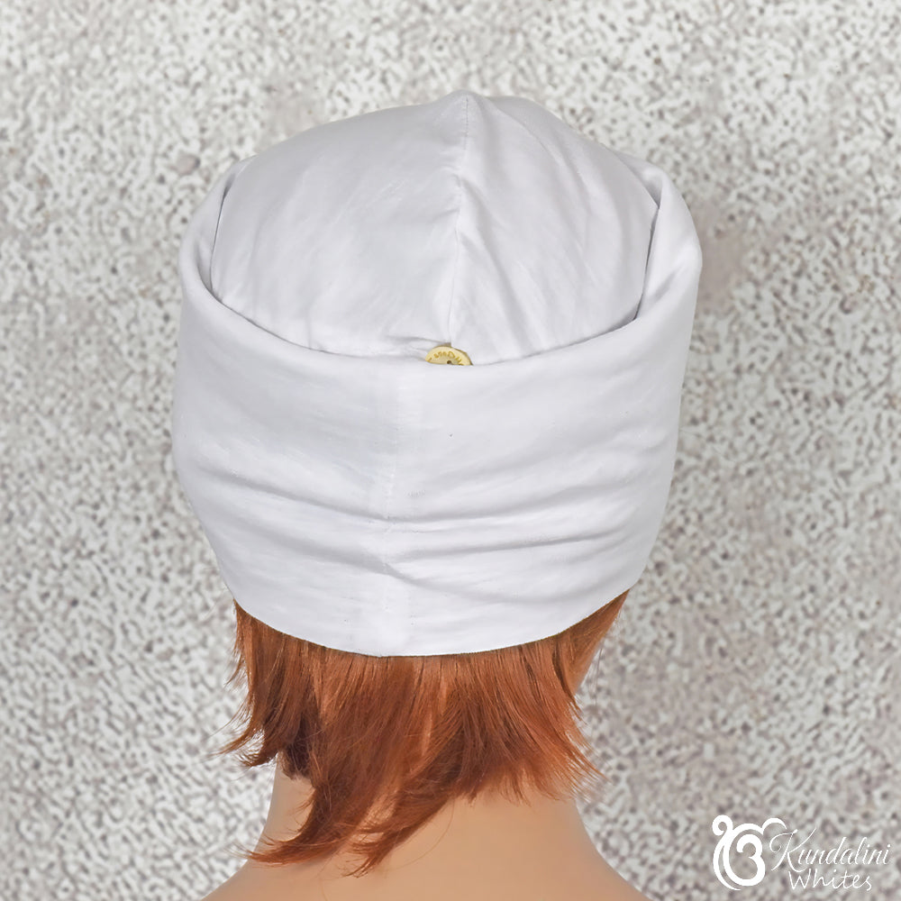 Person wearing a folded white fabric beanie on a textured gray background