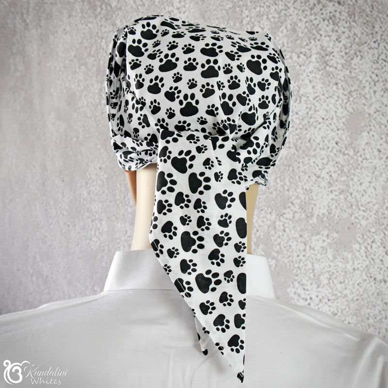 Black and white paw print headscarf on a mannequin with a gray textured background