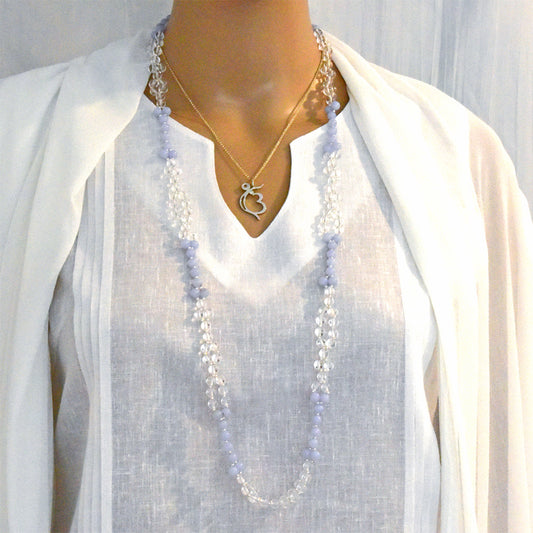 Mannequin wearing a long beaded necklace and a gold heart-shaped pendant on a white background