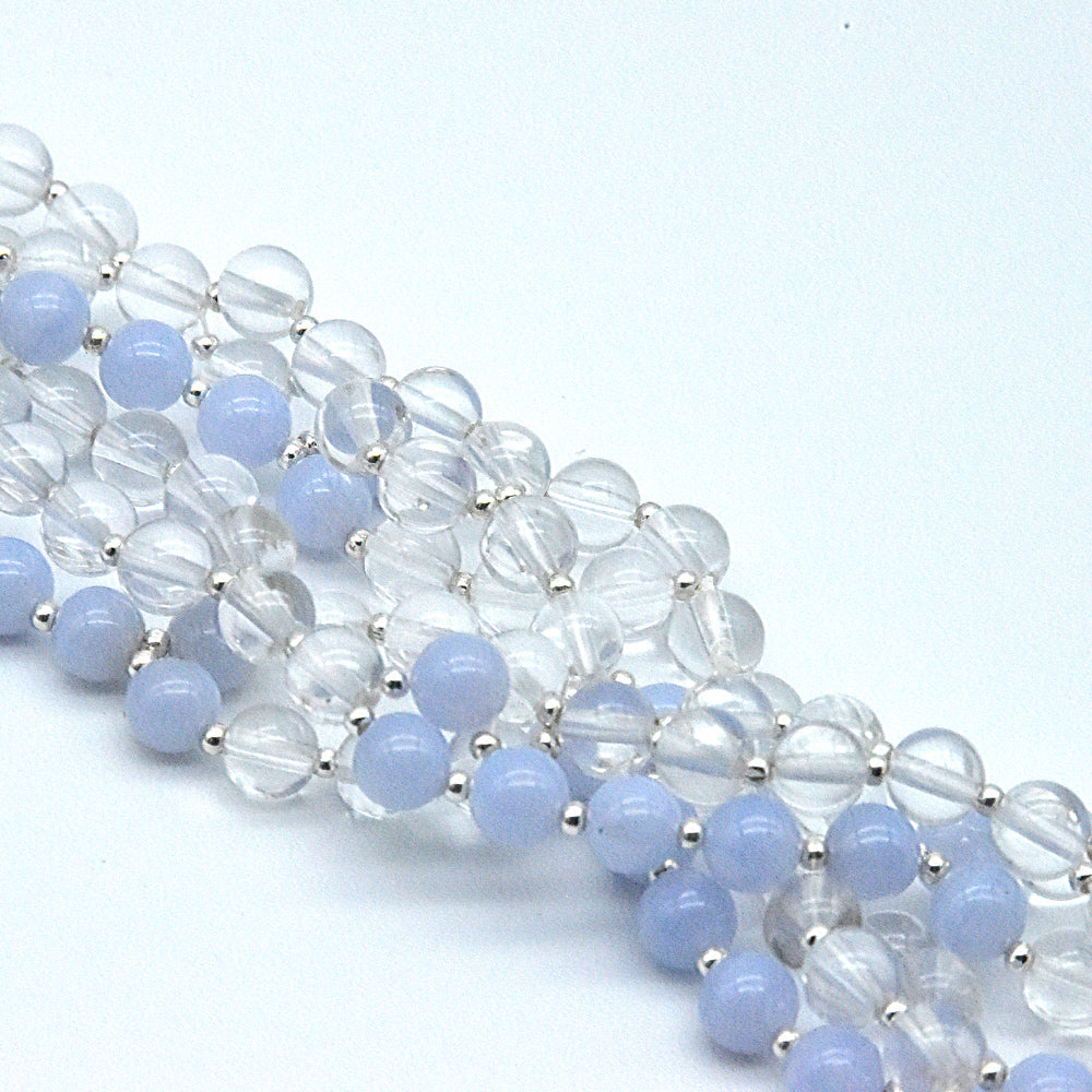 Beaded bracelet with blue and clear beads on a light blue background