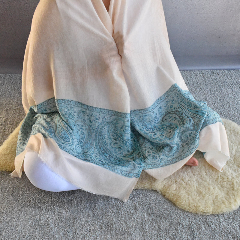 Beige scarf with blue pattern draped over a surface