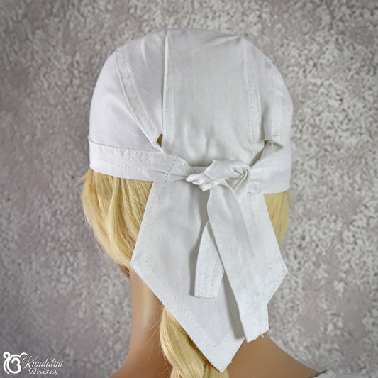 White headscarf with a bow on a mannequin head against a textured gray background