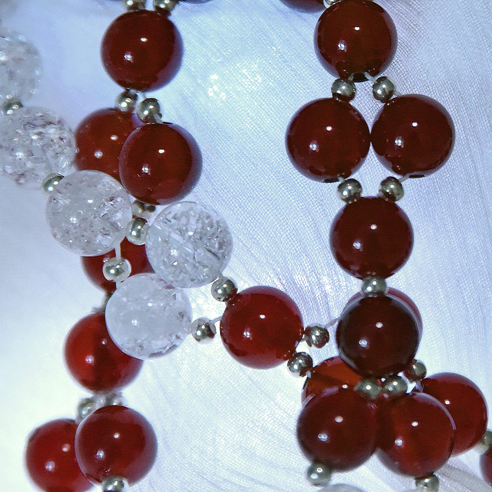 Necklace with red and clear beads on a white background