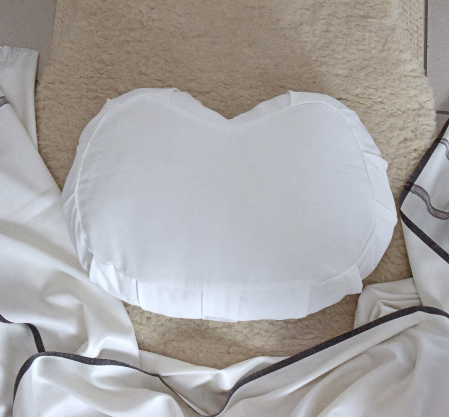 White meditation cushion on lamb's wool rug