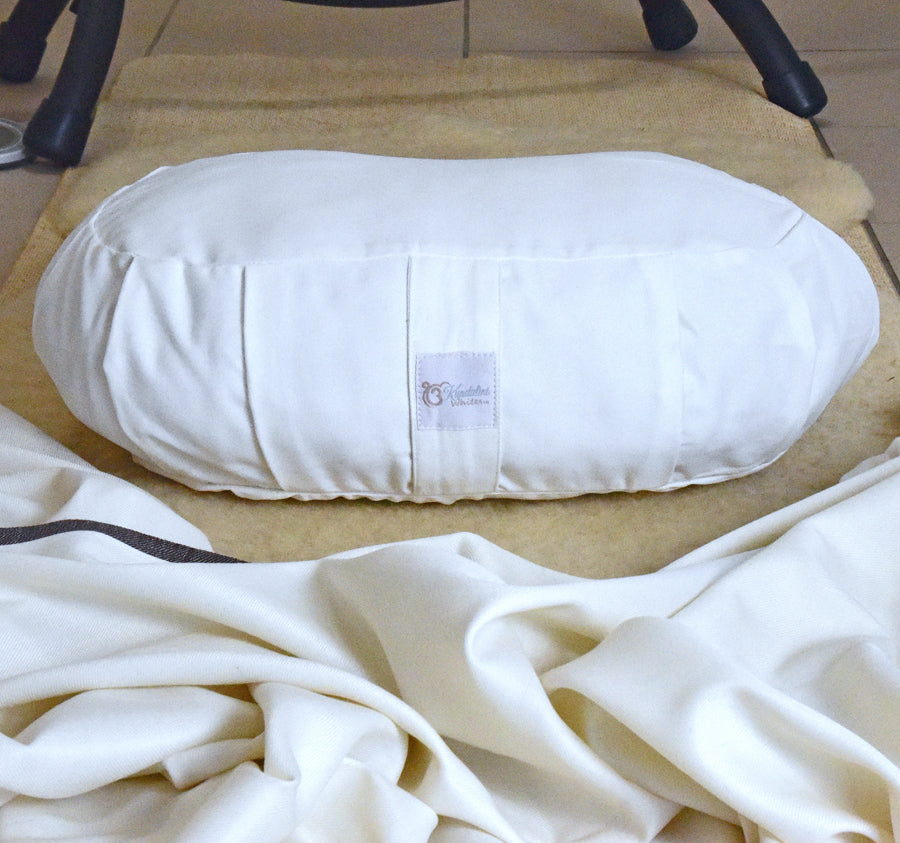 White cushion on a wooden floor with a brand label visible