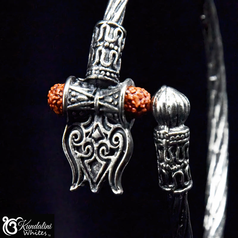 Close-up of a silver pendant with intricate designs on a black background