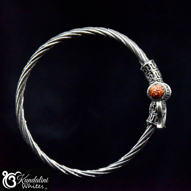 Silver bracelet with a bead on a black background