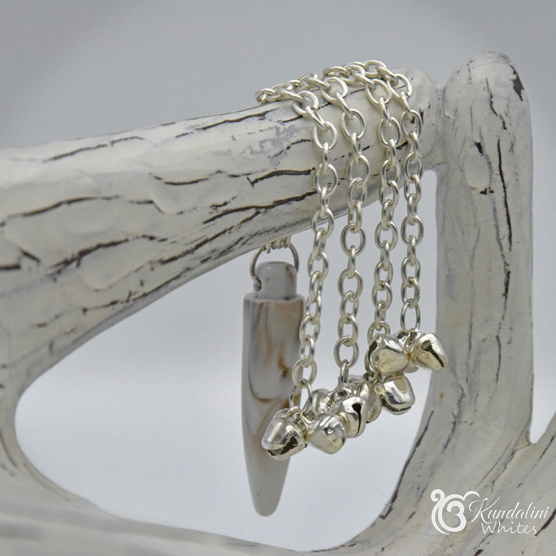 Silver ornament with heart pendants on a white wooden surface