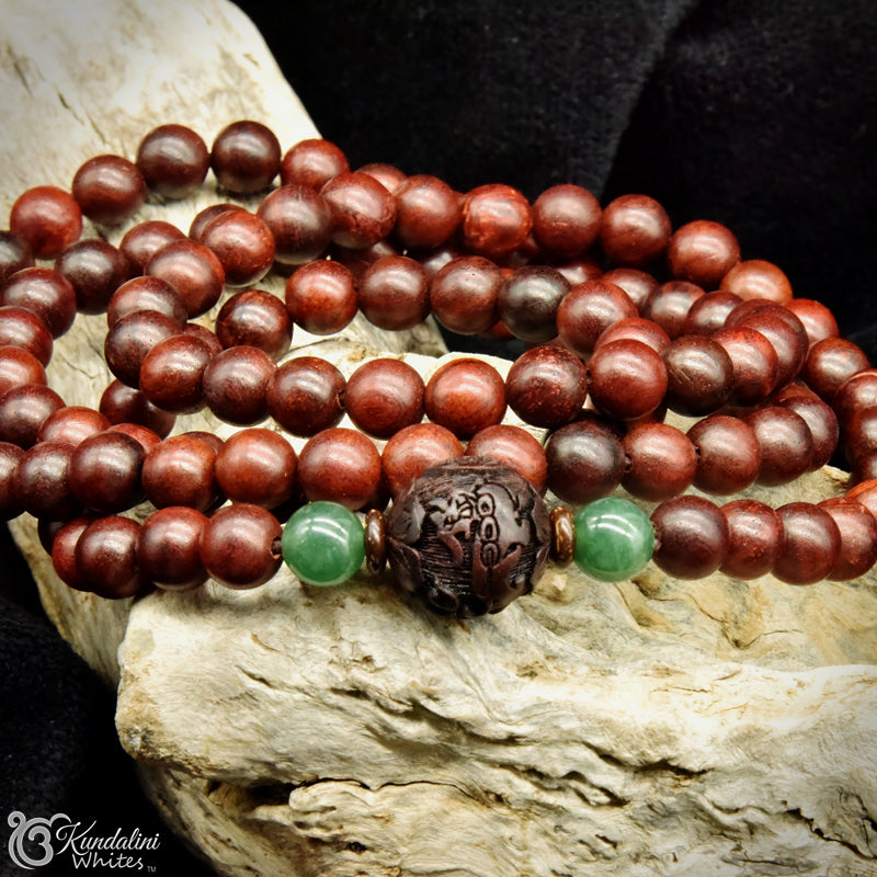 Wooden beaded necklace with green accents on a wooden surface
