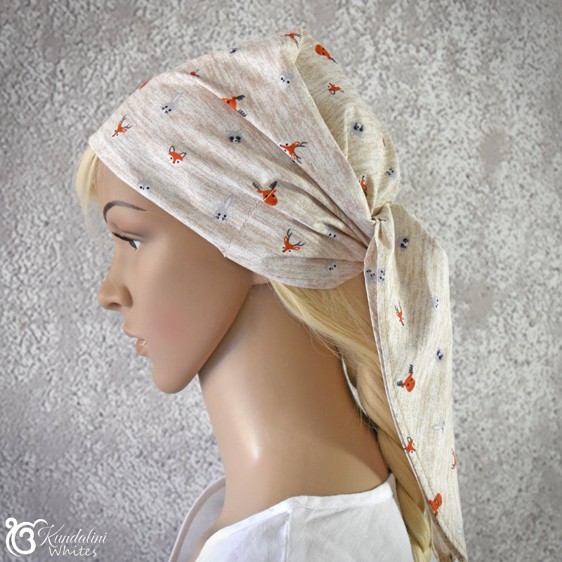 Mannequin head wearing a beige headscarf with fox pattern on a gray background
