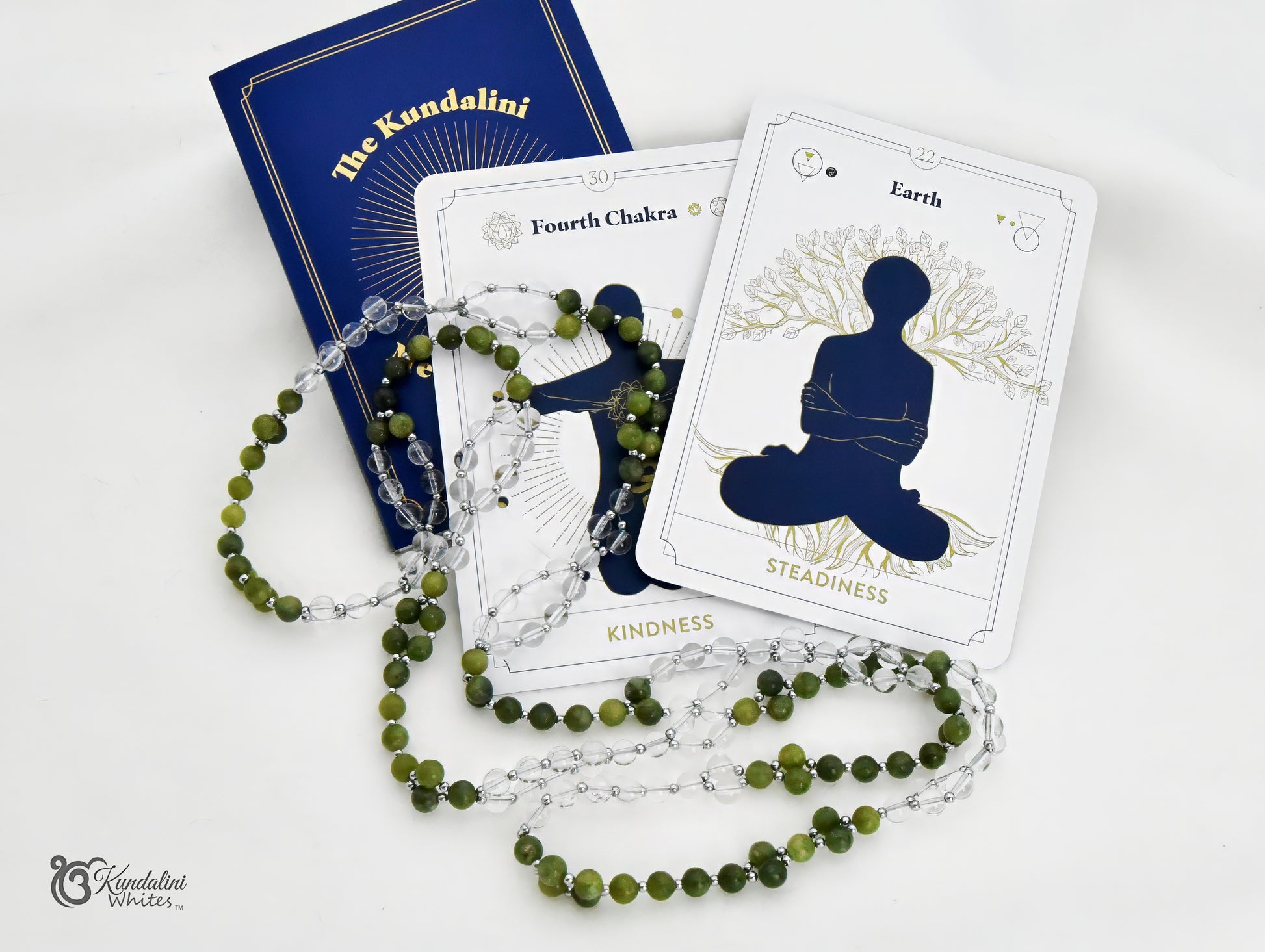 A spiritual kit featuring a blue 'The Kundalini Meditation Oracle' book, a white 'Earth' card with a meditating silhouette, and a green jade and clear quartz mala, arranged on a white background.