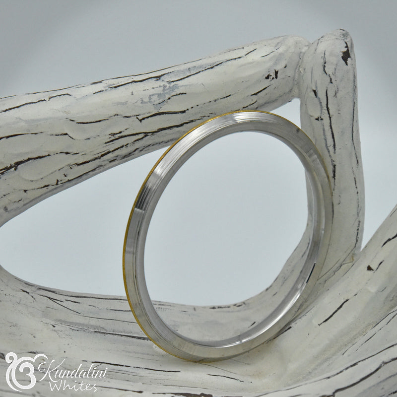 Steel Kara with brass centre on wooden backdrop