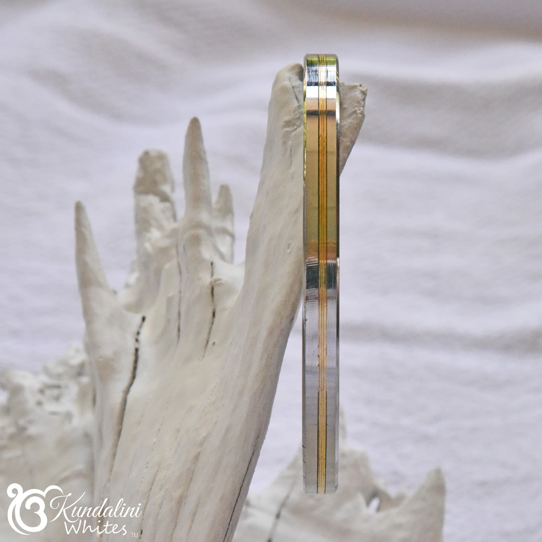 Clear bracelet with gold accents on a white surface, featuring the brand 'Kundalini Whites'.