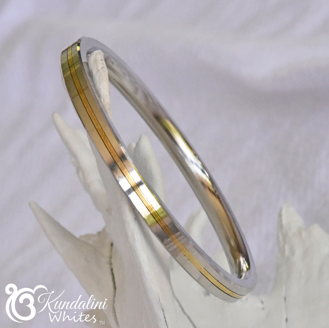 Two-toned silver and gold bracelet on a white background with 'Kundalini Whites' branding.